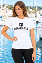 Mujer con camiseta blanca IMPARABL3 Sport Style, de manga corta y corte entallado, con logotipo I3 IMPARABL3 negro centrado en el pecho, en un puerto deportivo.