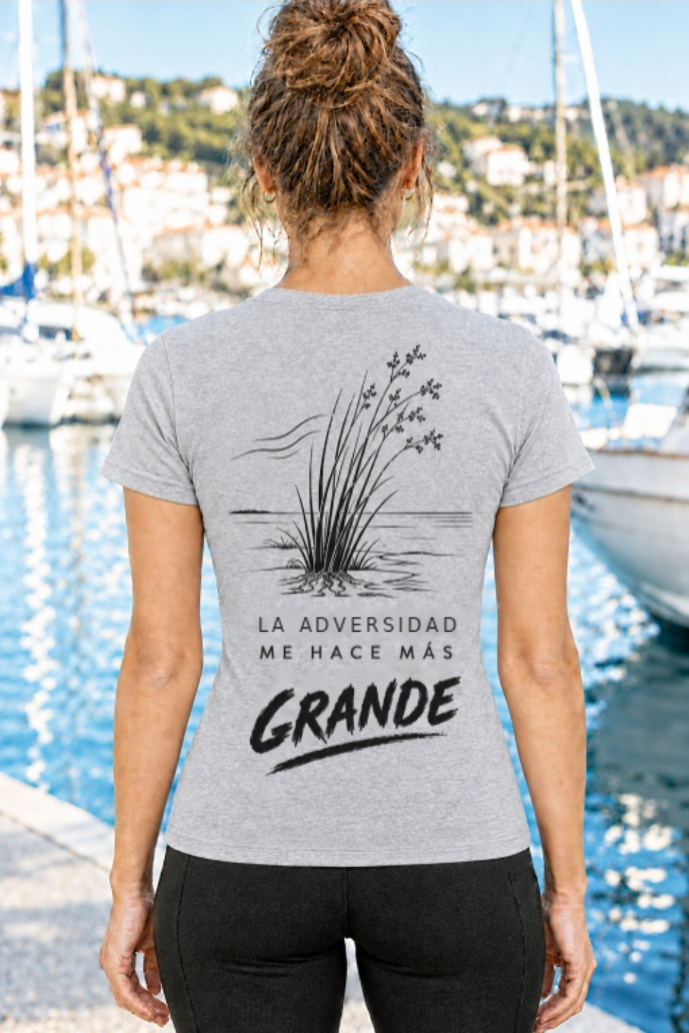 Vista trasera de camiseta gris de mujer IMPARABL3 Sport Style, con ilustración negra de juncos junto al agua y el mensaje motivacional «La dificultad me hace más grande».