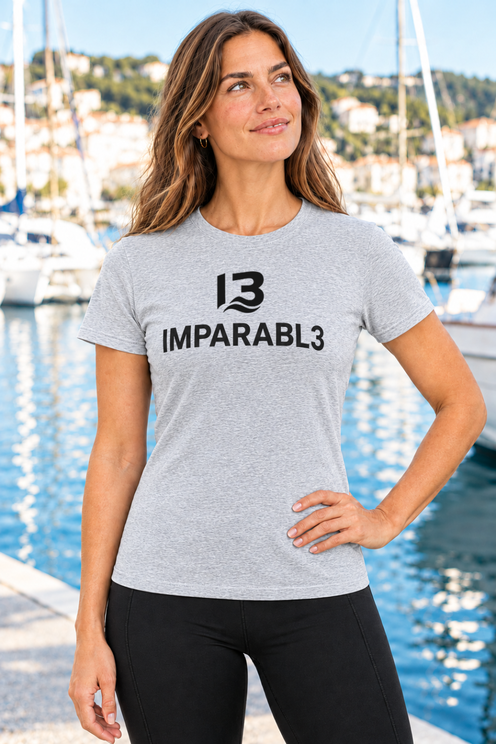Mujer con camiseta gris vigoré IMPARABL3 Sport Style, de manga corta y corte entallado, con logotipo I3 IMPARABL3 negro centrado en el pecho.