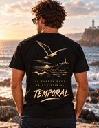 Camiseta negra de hombre Sport Style de IMPARABL3, vista trasera con ilustración dorada de gaviota, mar y faro y la frase «La fuerza nace de resistir al temporal».