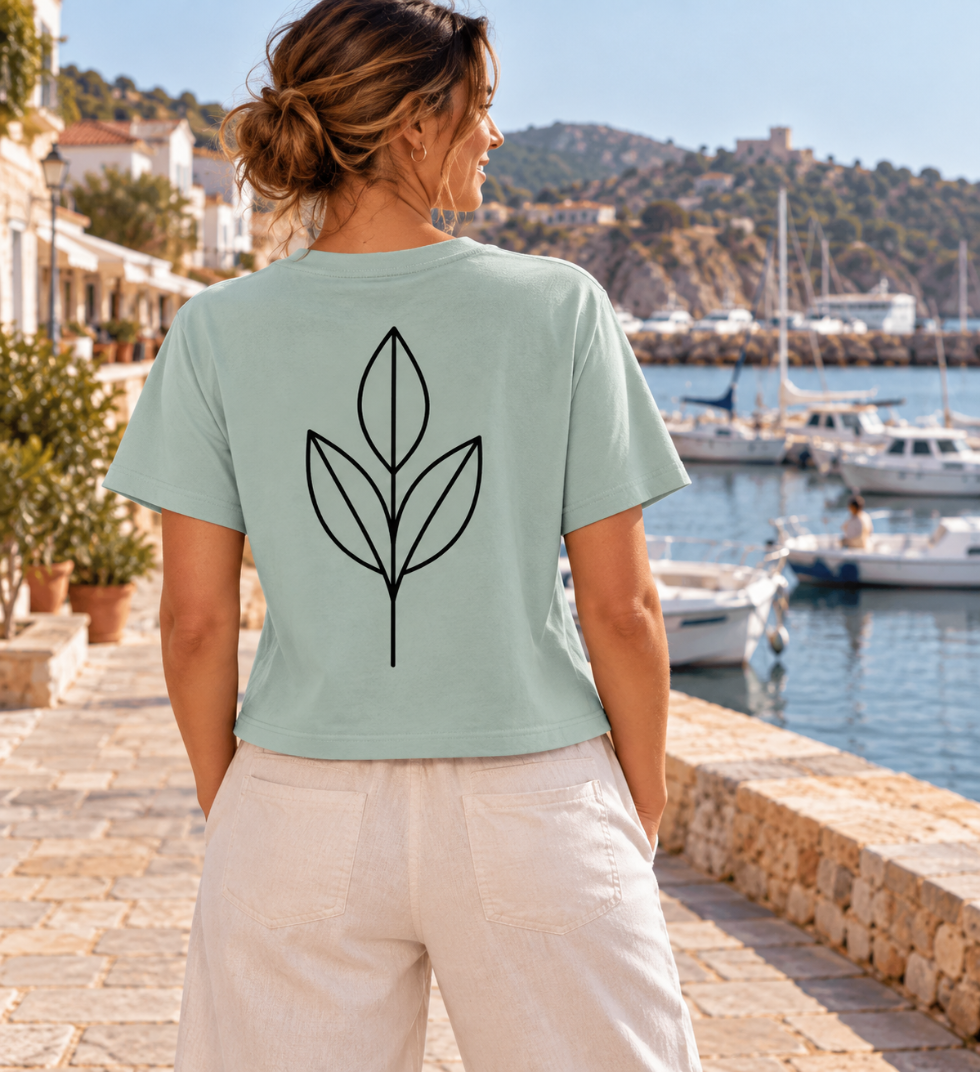 Vista trasera de la camiseta oversize de mujer en verde Mystic de IMPARABL3, con ilustración botánica minimalista negra y corte holgado de talle corto.