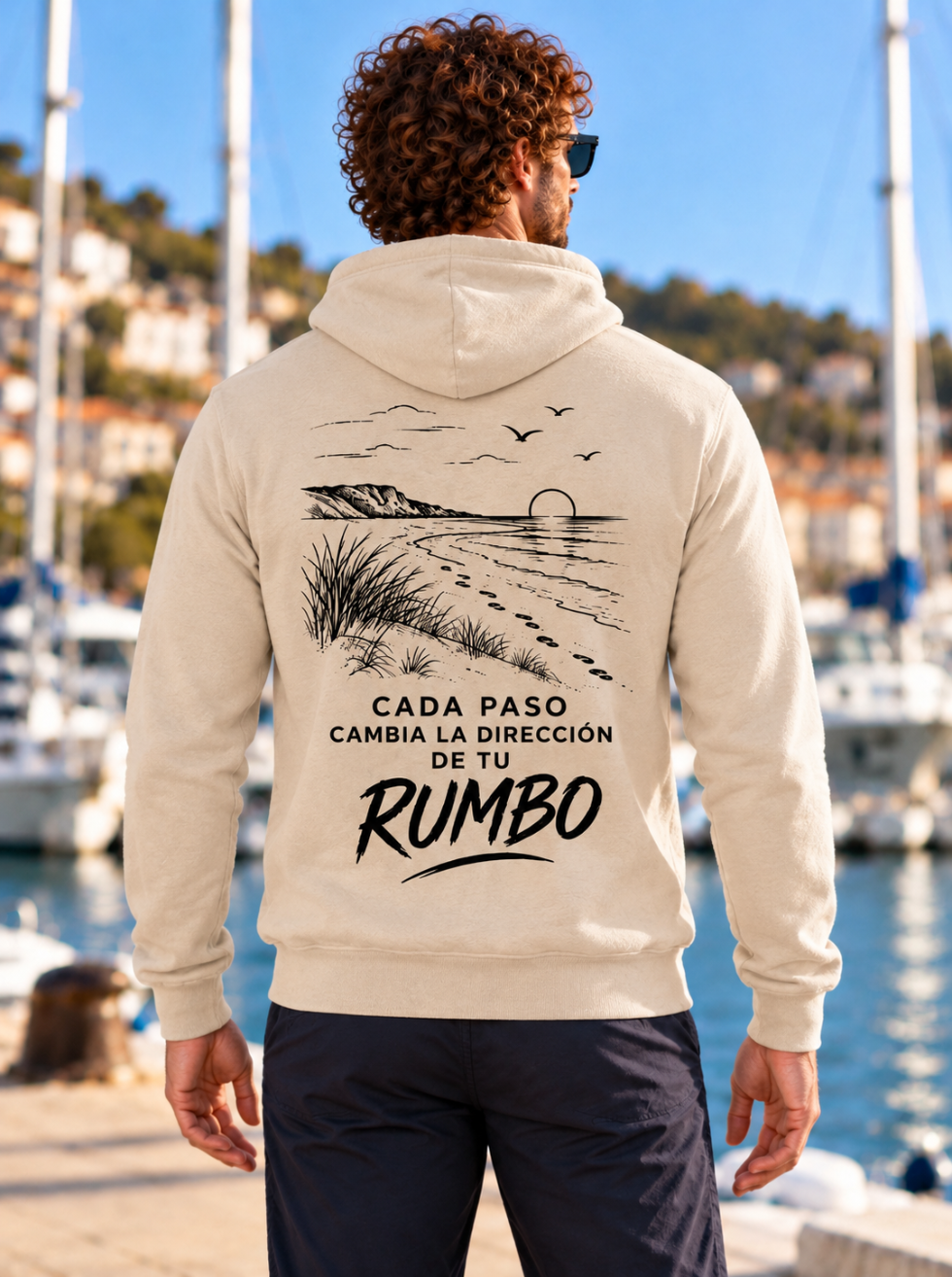 Sudadera arena de hombre Sport Style de IMPARABL3, vista trasera con paisaje de playa y huellas en negro y la frase «Cada paso cambia la dirección de tu rumbo».