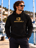 Modelo con sudadera negra de hombre Sport Style de IMPARABL3, con capucha, bolsillo canguro y logotipo dorado en el pecho, en un puerto deportivo.